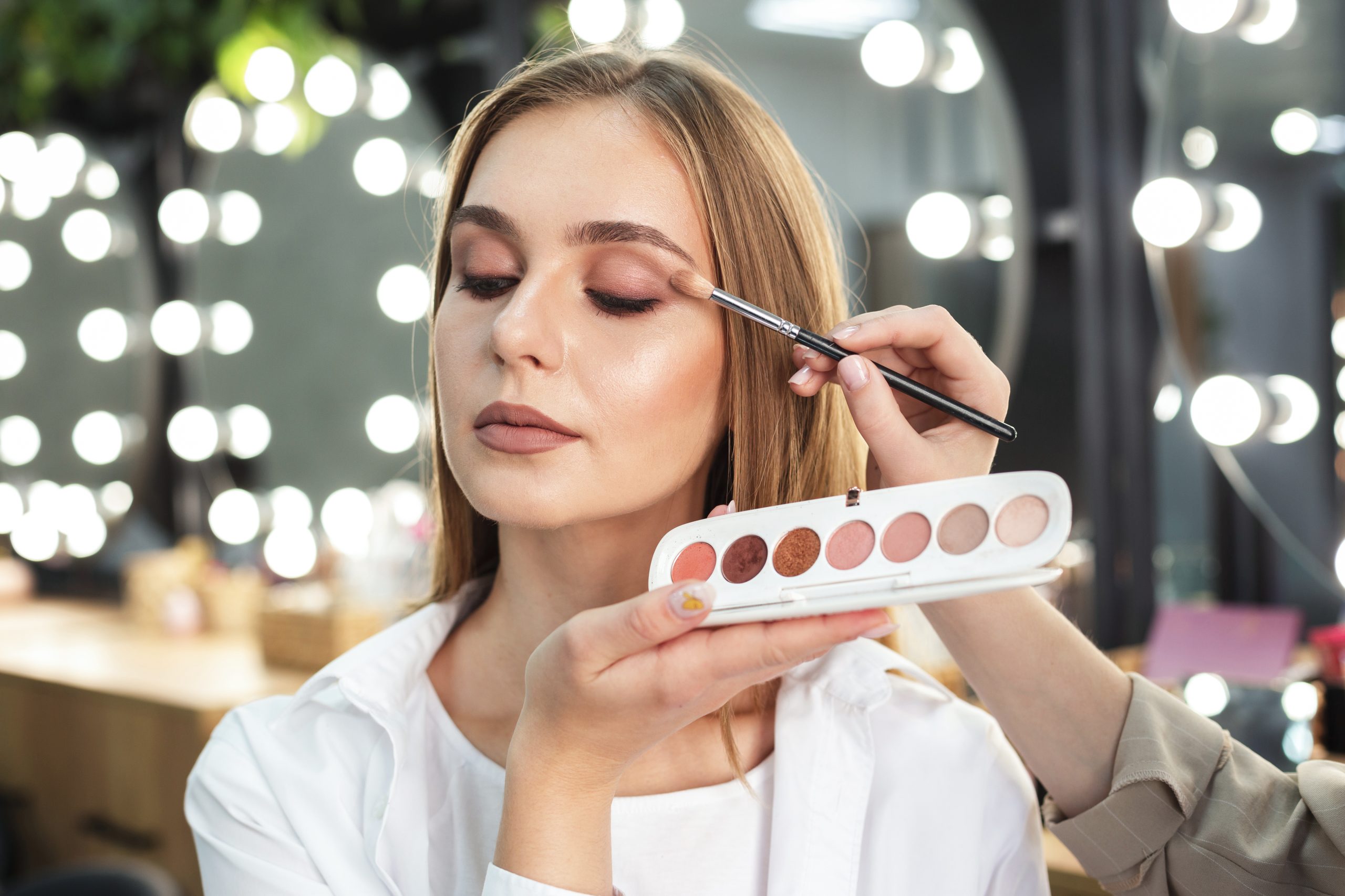 make up artist applying eyeshadow woman with brush scaled